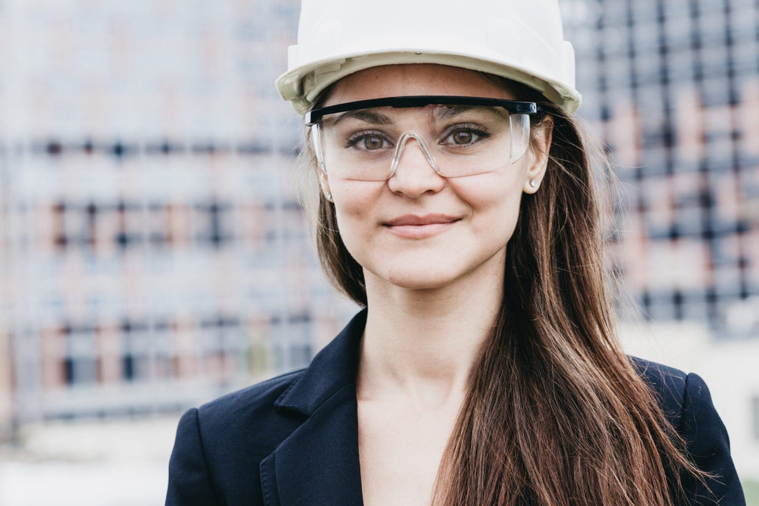 Smiling worker wearing safety googles and a hardhat 
