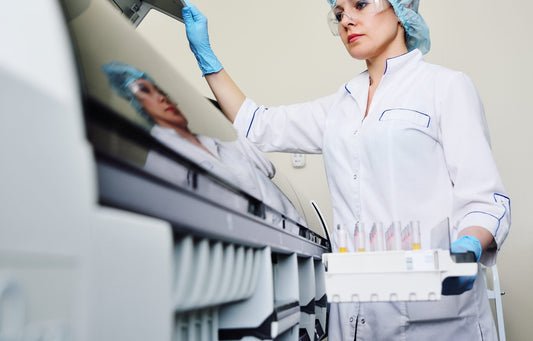 Lab worker wearing gloves and holding vials