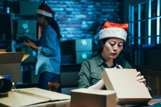 two workers wearing Santa hats 