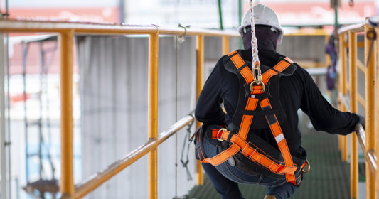 Worker on elevated platform with harness and hard hat
