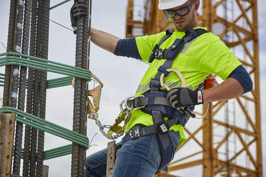 Construction worker demonstrating correct fall protection harness technique for safety training.